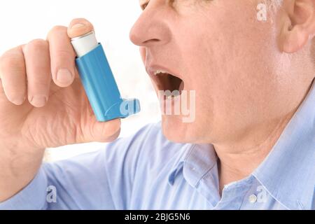 Elderly man using inhaler, closeup Stock Photo