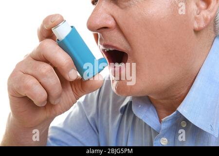 Elderly man using inhaler, closeup Stock Photo