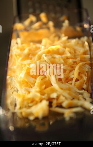 https://l450v.alamy.com/450v/2bjg75t/grated-cheese-in-plastic-container-closeup-2bjg75t.jpg