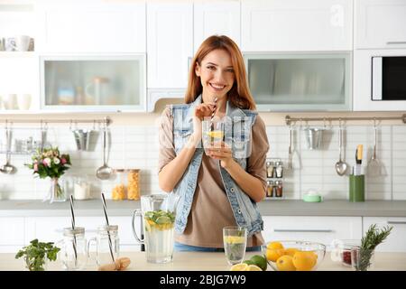 Beautiful young woman with lemonade in kitchen Stock Photo