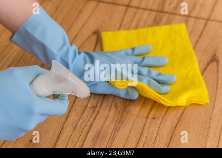 Disinfecting a table surface with rubbing alcohol for prevention of coronavirus. Stock Photo