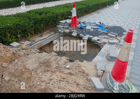 deep excavation with caution posts side of a road Stock Photo