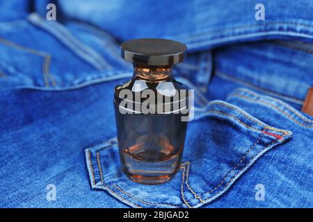 Perfume bottle on denim cloth Stock Photo