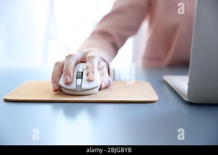 Woman using computer mouse with laptop on table Stock Photo