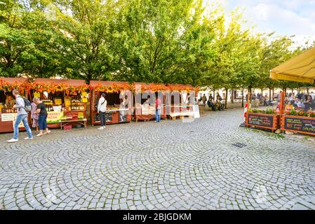 Tourists enjoy an Autumn day shopping and dining at cafes at the Kampa Island market square near Charles Bridge in Prague, Czech Republic Stock Photo