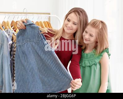 Mother and daughter choosing clothes in modern shop Stock Photo