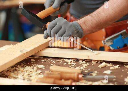 Carpenter with chisel and hammer in workshop, closeup Stock Photo