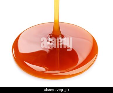 Pouring caramel sauce onto white background Stock Photo