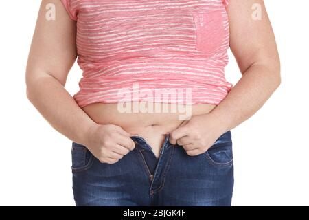Stout adult woman trying to put on tight jeans at home. Weight