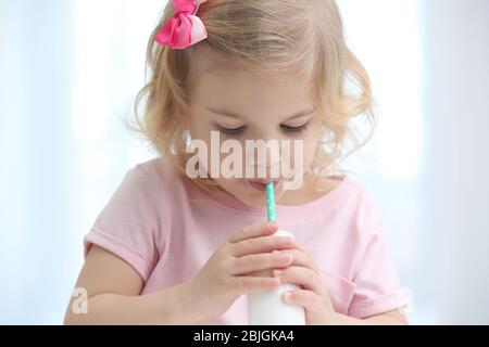 Cute little girl drinking yogurt at home Stock Photo