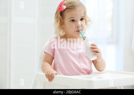 Cute little girl drinking yogurt at home Stock Photo