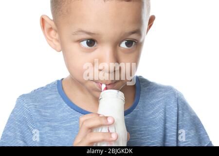 Cute African American boy drinking yogurt on white background, closeup Stock Photo