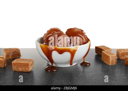 Bowl with chocolate ice cream and caramel sauce on table Stock Photo
