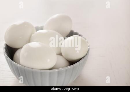 Bowl with hard boiled eggs on light background. Nutrition concept Stock Photo