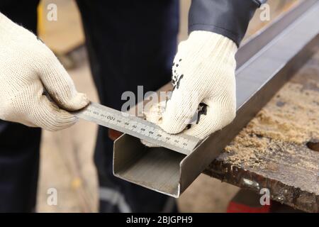 Man measuring off metal bar in workshop Stock Photo