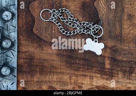 punched medieval belt on a wood background with  medal for dog and space for text Stock Photo