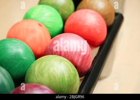 Colorful balls on rack in bowling club, closeup Stock Photo