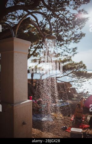 Public shower on the beach. Water jet on the shower standing on the