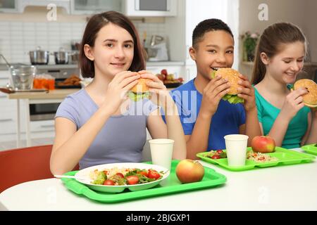 https://l450v.alamy.com/450v/2bjgxp1/children-eating-delicious-sandwiches-in-school-canteen-2bjgxp1.jpg