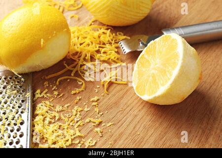 Fresh lemons, zest and tools on wooden table, closeup Stock Photo
