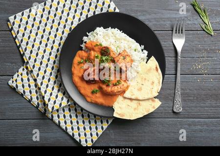 Plate with delicious Murgh Makhani and rice on table Stock Photo