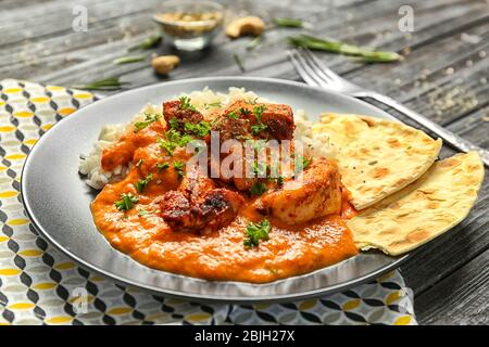 Plate with delicious Murgh Makhani and rice on table Stock Photo