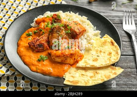 Plate with delicious Murgh Makhani and rice on table Stock Photo