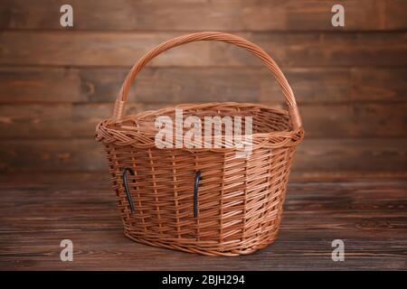 Bicycle wicker basket on wooden table Stock Photo