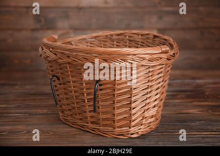 Bicycle wicker basket on wooden table Stock Photo