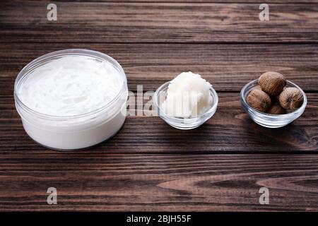 Shea butter, nuts and cream on wooden table Stock Photo