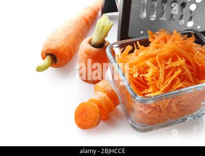 Bowl with carrot and grater on white background Stock Photo