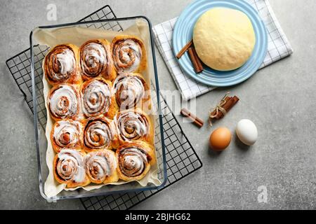 Tasty cinnamon rolls in baking dish on table Stock Photo