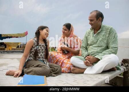 Indian mother and father helping daughters with homework Stock Photo