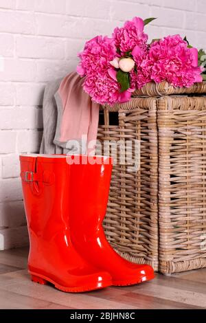 Red wellington boots on floor near brick wall Stock Photo
