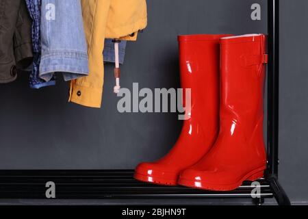 Red wellington boots on shelf near wall Stock Photo
