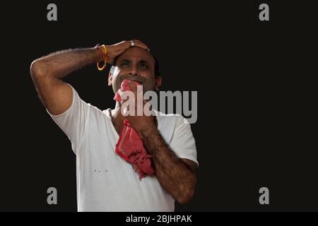 Depressed Indian farmer standing and holding his head in disbelief ...