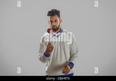 A bowler tossing the ball on grey background Stock Photo