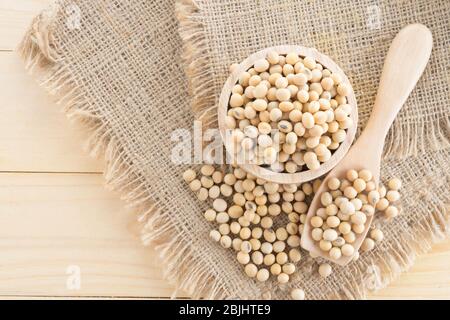 soybean in wood cup  on sack background Stock Photo