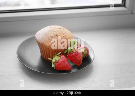 Delicious muffin on windowsill Stock Photo