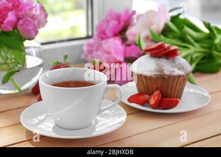 Delicious muffin and cup of tea on windowsill Stock Photo