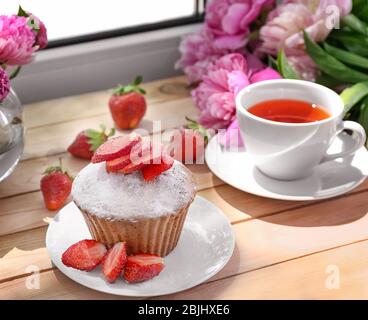 Delicious muffin and cup of tea on windowsill Stock Photo