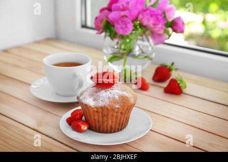Delicious muffin and cup of tea on windowsill Stock Photo