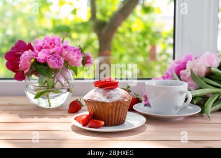 Delicious muffin and cup of tea on windowsill Stock Photo