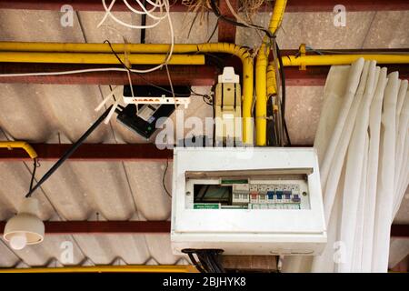 Old electricity control panel broken and damage on wooden pole in retro house in countryside of Thailand Stock Photo