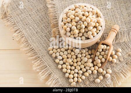soybean in wood cup  on sack background Stock Photo