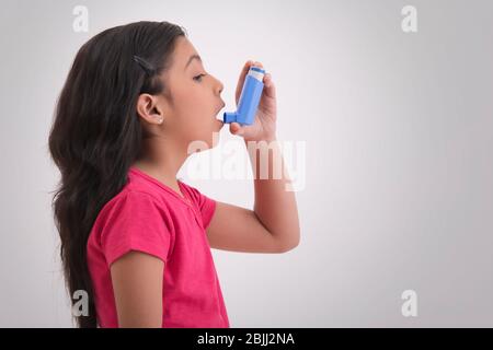 Young asthma patient taking an inhaler. (Children) Stock Photo