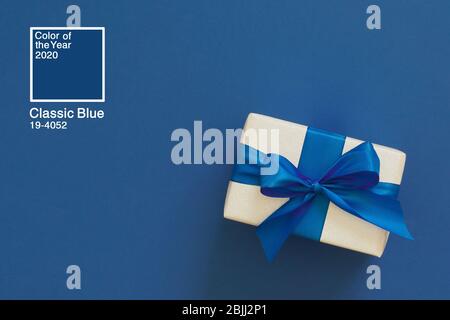 Festive Christmas decor on a blue classic background. Silver gift boxes, sparkles, ribbons, bows. Color of the year 2020. Stock Photo