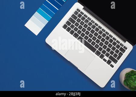 Classic Blue. Color of the Year 2020. Top view of workspace with laptop, succulent and glasses and copy space on blue background. Flatlay minimalism Stock Photo