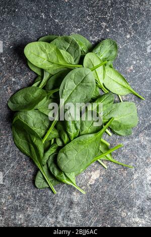 Baby spinach leaves. Green spinach on kitchen table. Top view. Stock Photo