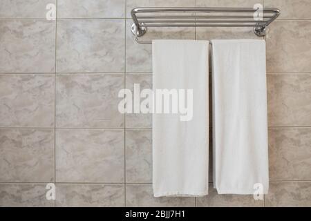 Dryer with towels on wall in light modern bathroom Stock Photo